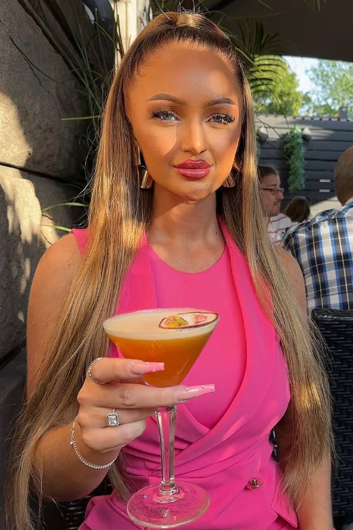 @christinalegreid tar en drink på en restaurant og har på seg en sexy rosa kjole.