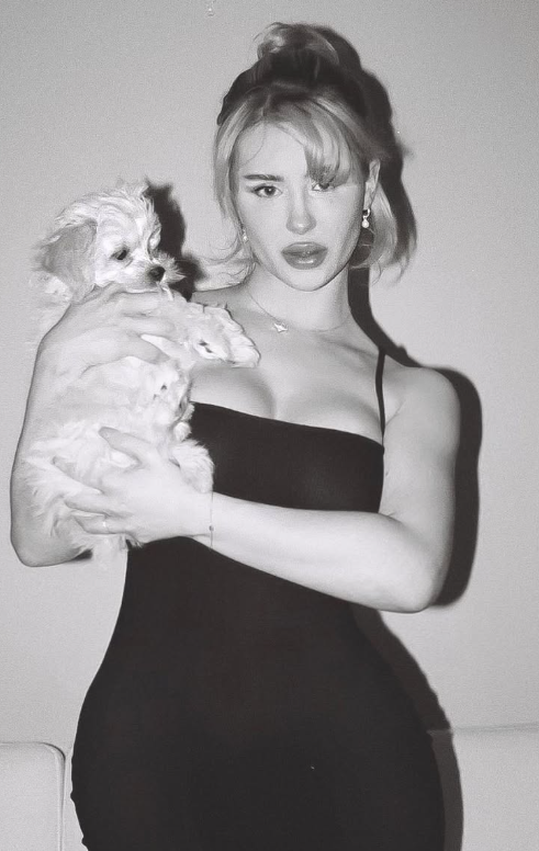 Amalie Olufsen tar et bilde med hunden sin mens hun kledd i en sexy svart kjole.