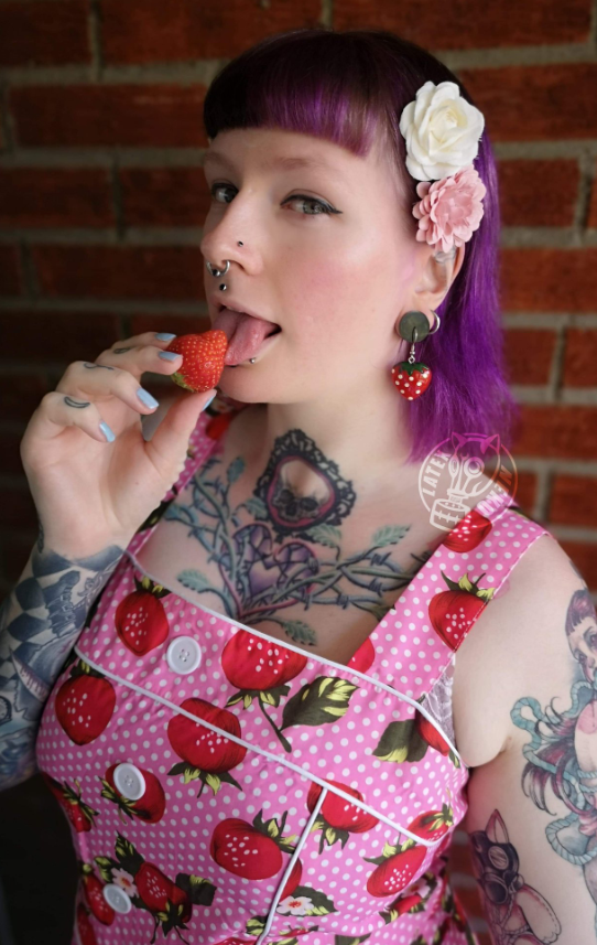 @latex_neko tar et bilde mens hun har på seg et sexy rosa forkle mens hun slikker et jordbær.