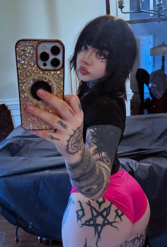 @triplexceleste tar bilde på rommet sitt kledd i en svart crop-topp og sexy rosa truser.