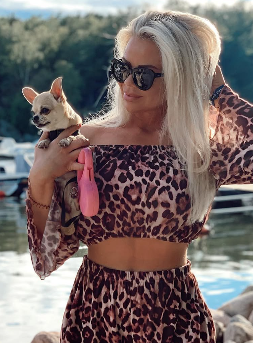 @julianyland tar et bilde med hunden sin, kledd i en leopardprint-topp og matchende bukser.