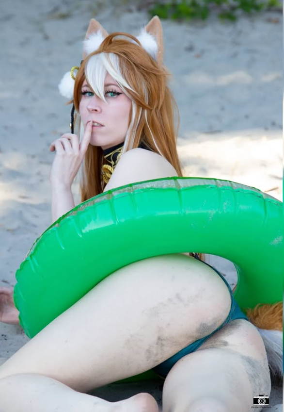 Ereneru taking a picture lying on the beach and dressed in a sexy bikini with a floater around her waist.