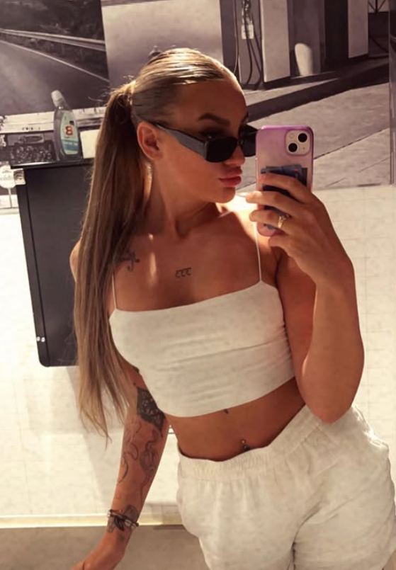 Julie Linnea Hovelsen tar et bilde i en sexy hvit crop top og hvite bukser.