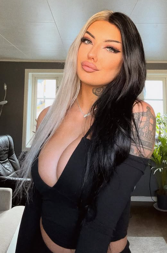 Lisa Johansen tar et bilde mens hun er kledd i en sexy svart, lavt snitt kjoletopp