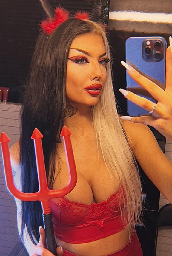 Lisa Johansen tar et bilde i sexy rĂždt undertĂžy mens hun holder en rĂžd trefork.