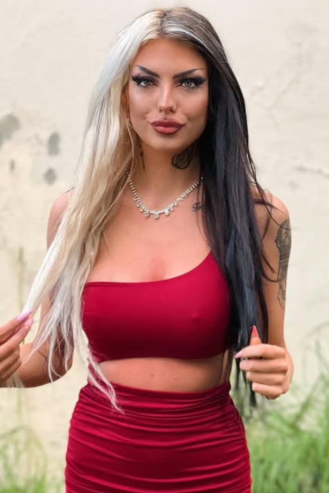 Lisa Johansen tar et bilde mens hun er kledd i en sexy rĂžd crop-topp og et matchende rĂždt skjĂžrt.