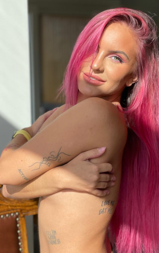 Siv Nerdal tar et bilde med hånden over brystene sine med rosa hår.