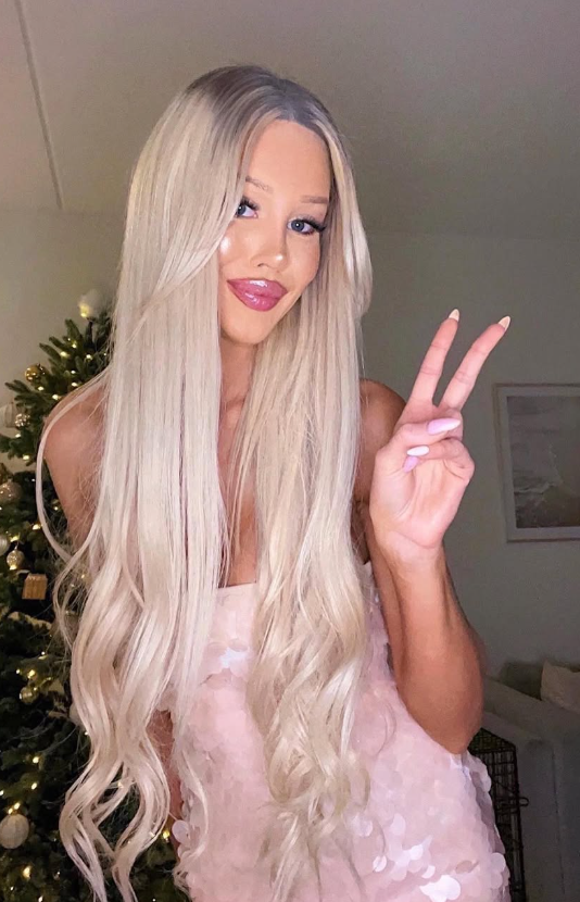 Julie Olivia tok et bilde foran et juletre og kledde seg i et sexy rosa antrekk.