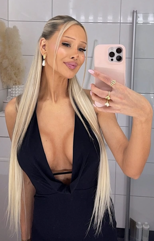 Julie Olivia tar et bilde på badet sitt og har på seg en sexy svart, nedringet kjole.