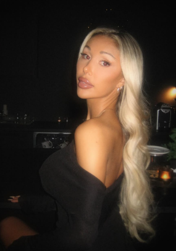 Caroline Nitter tar et bilde mens hun er kledd i en sexy svart kjole.