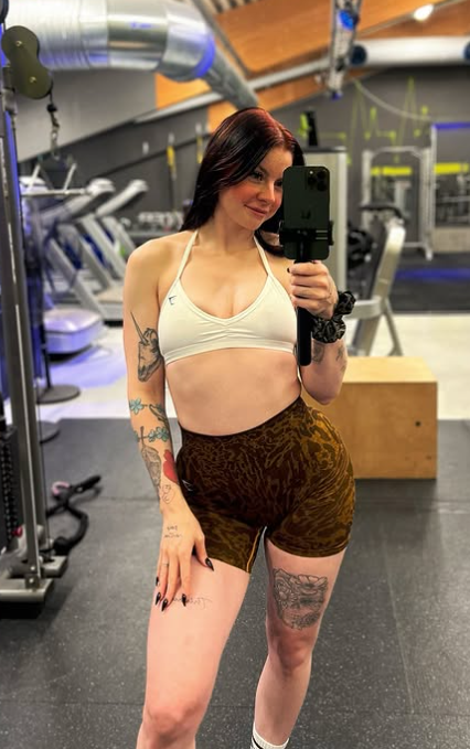 Ann Helen Lund tar et bilde på treningsstudioet, kledd i en sexy hvit topp og brune strømpebukser.