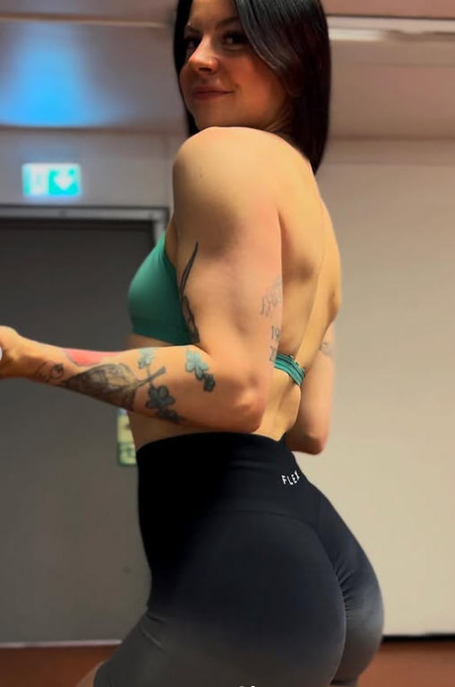 Ann Helen Lund tar et bilde kledd i en sexy grønn crop-topp og svarte strømpebukser.