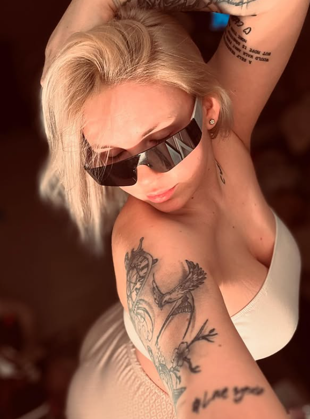 Anja Erika tar et bilde kledd i en sexy hvit topp og beige bukser