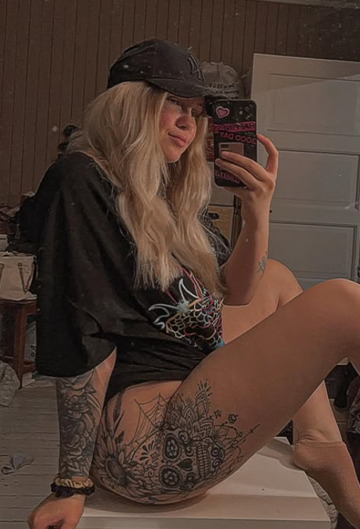 Anja Erika tar et bilde i en sexy svart skjorte og baseballcaps.