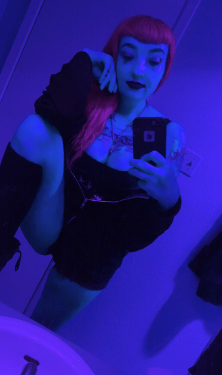 Brittani Rose tar et bilde i en sexy, svart outfit og en rød parykk.