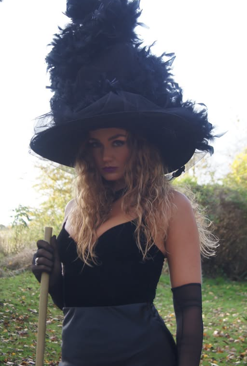 Thalemyhre tar et bilde mens hun er kledd i et sexy svart cosplay-heksantrekk.