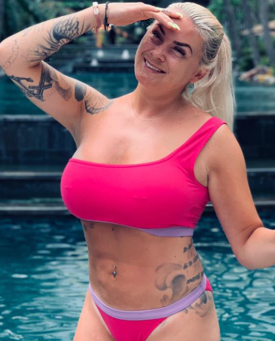 Lene Antonsen i rosa bikini tar et bilde i nærheten av et svømmebasseng